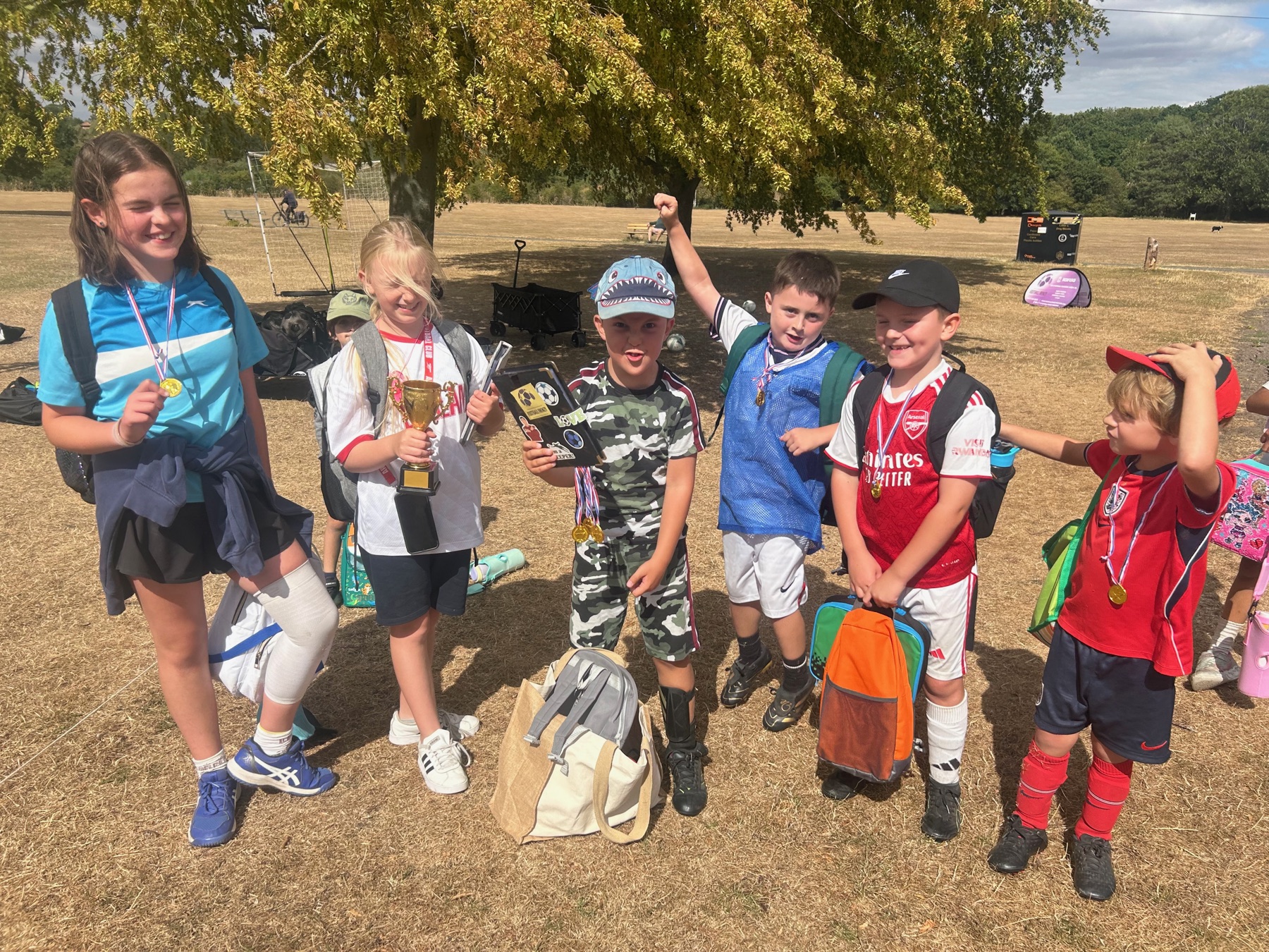 Football Frenzy children celebrating together with medals and a trophy